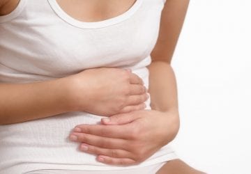 woman holding her stomach with cramps