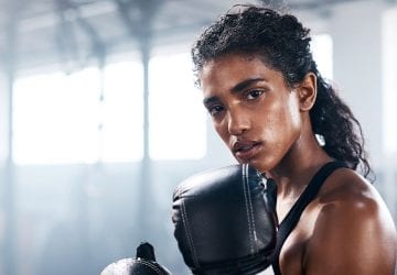 woman boxing in a gym looking into the camera