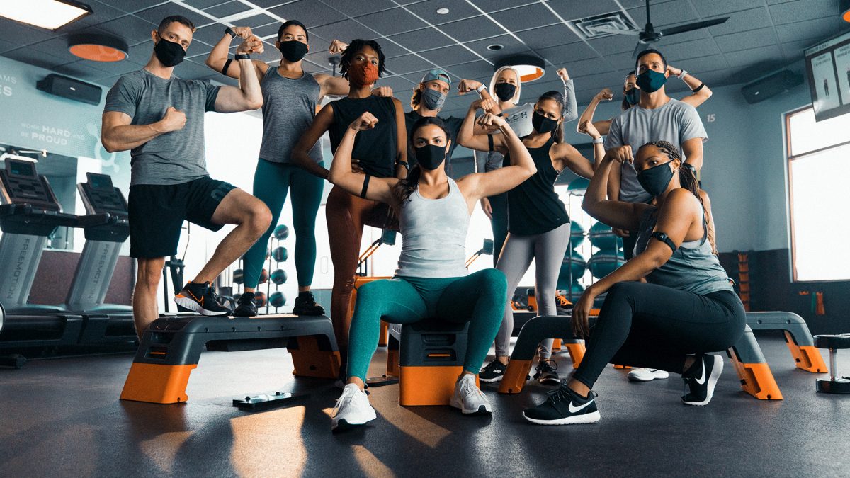 a group of masked trainers in the gym