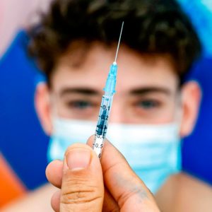 A 16-year-old teenager, receives a dose of the Pfizer-BioNtech COVID-19 coronavirus vaccine at Clalit Health Services, in Israel's Mediterranean coastal city of Tel Aviv on January 23, 2021. - Israel began administering novel coronavirus vaccines to teenagers as it pushed ahead with its inoculation drive, with a quarter of the population now vaccinated, health officials said.