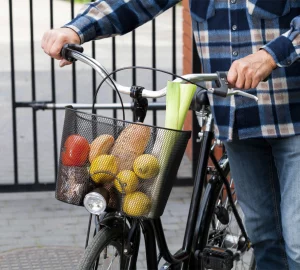 a man carrying groceries in his bike basket