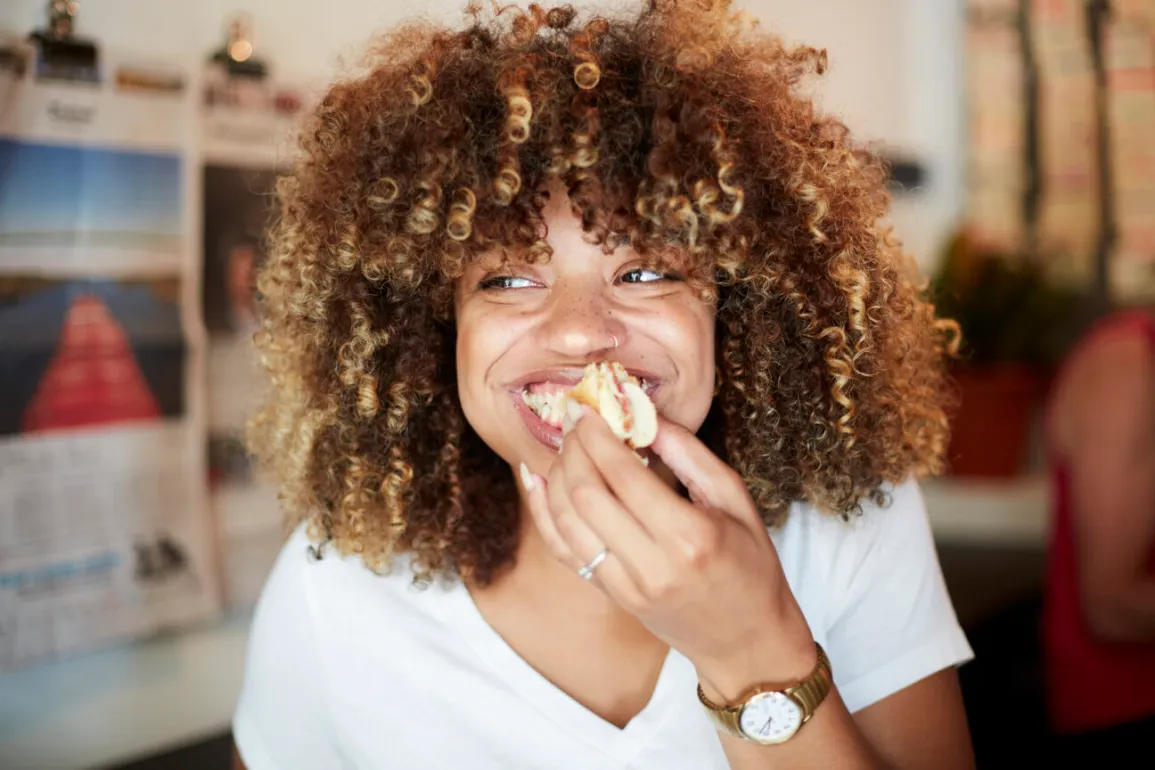 a woman eating and smiling