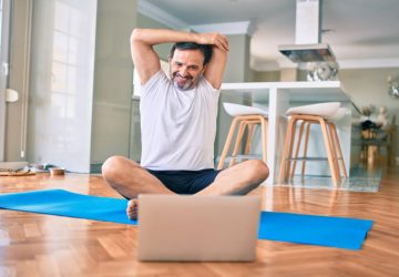 a man stretching in front of the computer