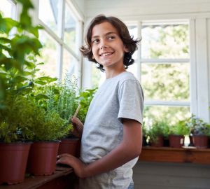 a young child standing by some indoor plants