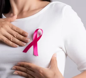 a woman with a pink ribbon on her chest
