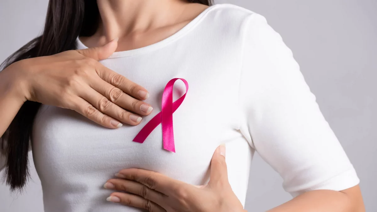 a woman with a pink ribbon on her chest