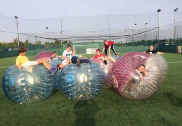 a group of kids playing in zorb balls