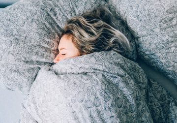 a woman under the blankets sleeping