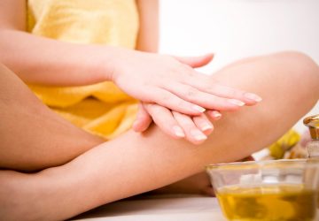 a woman applying castor oil to her hands