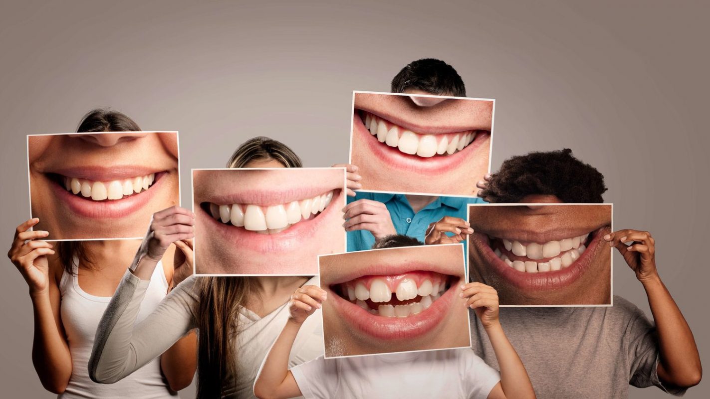 a group of people holding photos of smiles