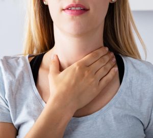 a woman holding her thyroid