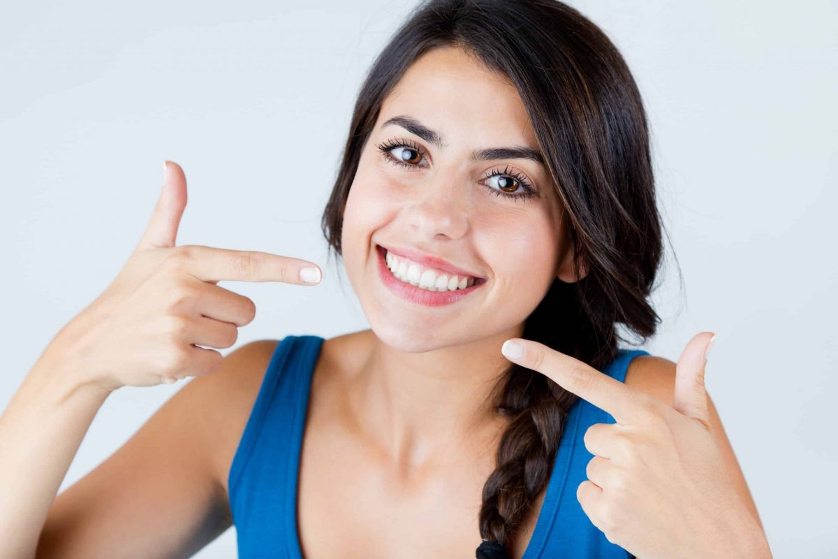 a woman pointing at her white smile