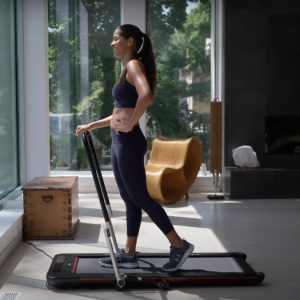 a woman walking on a foldable treadmill