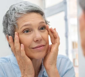 a woman with grey hair looking at herself in the mirror