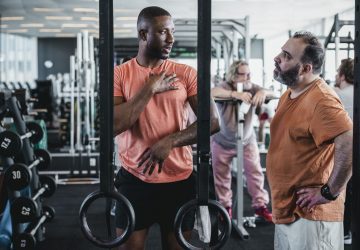 a trainer talking to a client in the gym