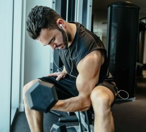 a man doing arm curls in the gym