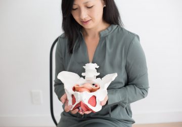 a woman showing a model of the pelvis